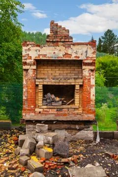 Old poor destroyed fireplace standing on the street with firewood inside, aft 写真素材