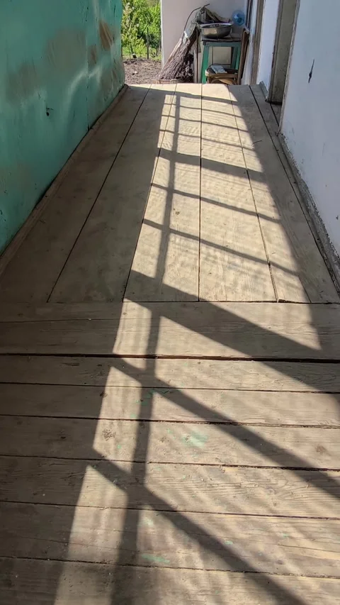 Old porch, dramatic window shadows on a weathered, rustic wooden deck. Stock Footage 334840642