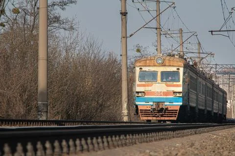 Old post soviet train rides by rail during the day. Electric train ER9. Stock Photos