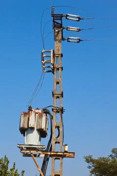 Old power transformator against blue sky Stock Photos