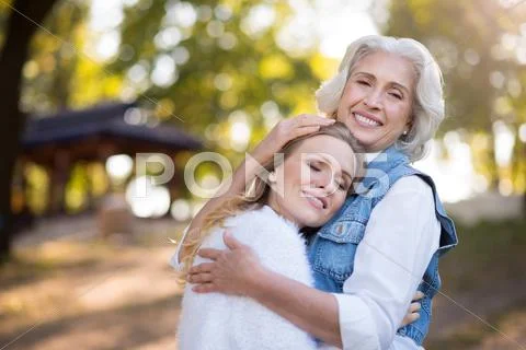 Old pretty woman hugging her daughter Stock Photos