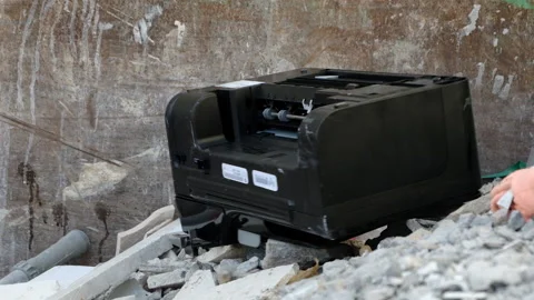 An old printer falls thrown away into a dumpster container with building wast Stock Footage 220672911
