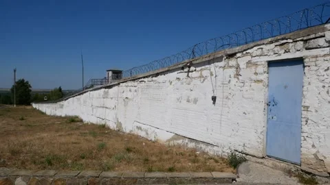 Old prison. Barbed wire. White wall with metal barbed fence. Stock Footage 140019569