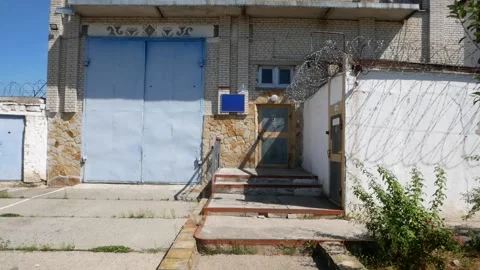 Old prison. Barbed wire. White wall with metal barbed fence. Video stock 140241437