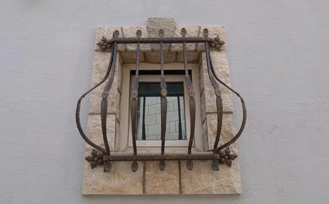 An old prison window secured with stylish bars Stock Photos