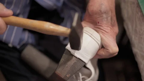 Old professional shoemaker working with hammer in workshop, senior man hands Stock Footage 142589172