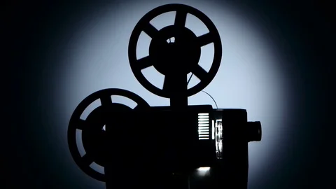 Old projector turns the tape. Dark silhouette studio Vidéo 73662299