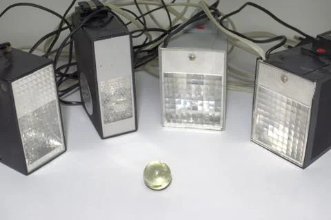 Old pulse electronic flashes, surrounding the small glass ball Stock Photos