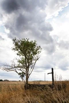 Old pump with dry soil, dramatic cloudy sky, water shortage Stock Photos
