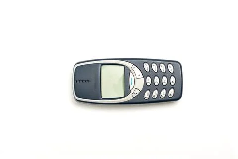 Old push-button mobile phone with green screen isolated on white background. Stock Photos