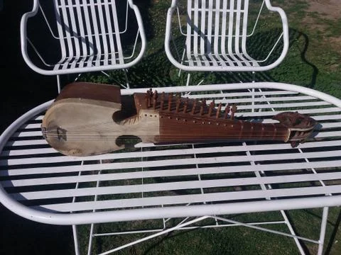An old rabab is kept on a table in a garden Stock Photos