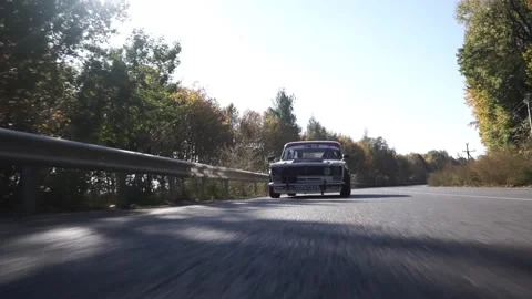 An old racing car is driving fast on the forest road. Extreme car driving Stock Footage 247197399