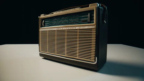 Old radio transistor standing on table in dark room closeup. Vintage FM receiver Stock Footage 332668581