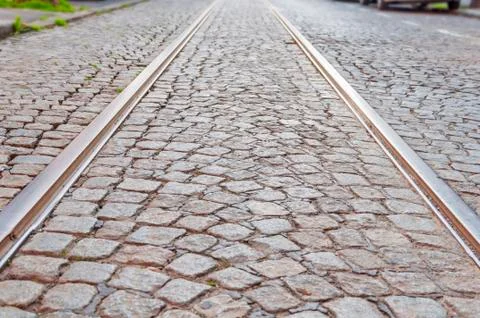 Old rail lines on cobbled road surface Stock Photos