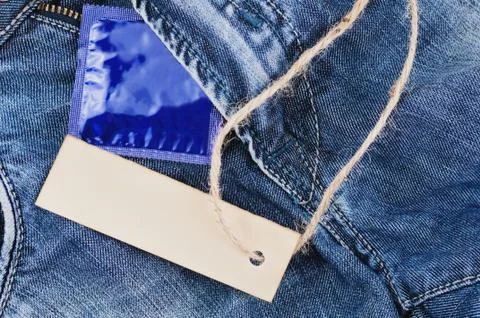 Old rectangular clean paper and brown rope near condom in blue package Foto stock