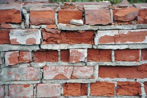 Old red and yellow bricks on the wall texture with pieces of plaster and pain Stock Photos
