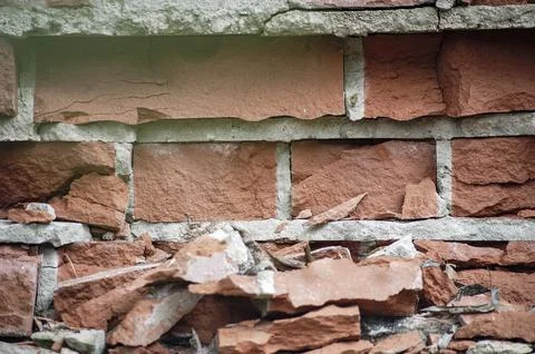 Old red and yellow bricks on the wall texture with pieces of plaster and pain Stock Photos