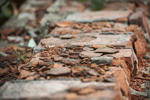 Old red and yellow bricks on the wall texture with pieces of plaster and pain Stock Photos