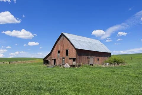 Old red barn under a bright blue sky. Stock Photos