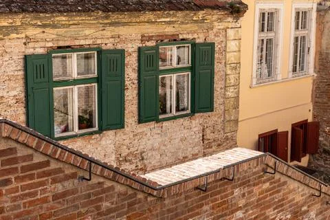 Old Red Brick Building Wall with Green Window Shutters Stock Photos