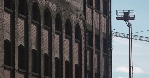 Old red brick derelict building facade with construction crane platform Stock Footage 341769142