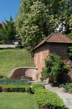 Old red brick fortification wall with clay tile roof in Warsaw public park Stock Photos