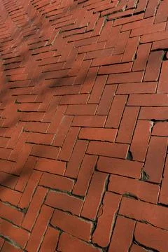Old red brick paver texture in herringbone pattern weathered pavement background Stock Photos