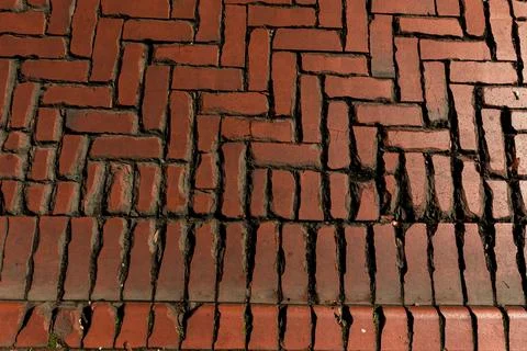 Old red brick paver texture in herringbone pattern weathered pavement background Stock Photos