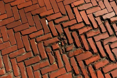 Old red brick paver texture in herringbone pattern weathered pavement background Stock Photos