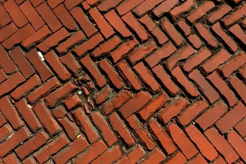 Old red brick paver texture in herringbone pattern weathered pavement background Stock Photos