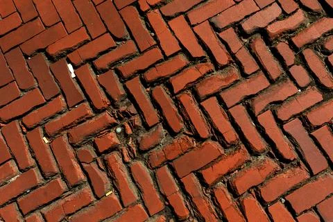 Old red brick paver texture in herringbone pattern weathered pavement background Stock Photos