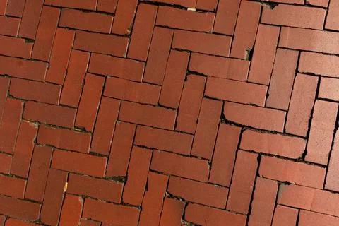 Old red brick paver texture in herringbone pattern weathered pavement background Stock Photos