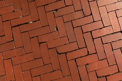 Old red brick paver texture in herringbone pattern weathered pavement background Stock Photos