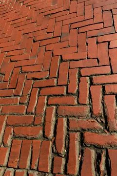 Old red brick paver texture in herringbone pattern weathered pavement background Stock Photos