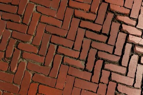 Old red brick paver texture in herringbone pattern weathered pavement background Stock Photos