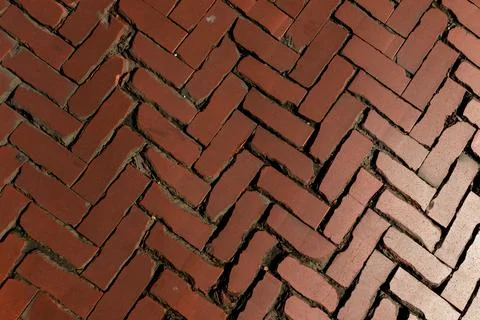 Old red brick paver texture in herringbone pattern weathered pavement background Stock Photos