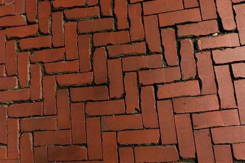 Old red brick paver texture in herringbone pattern weathered pavement background Stock Photos