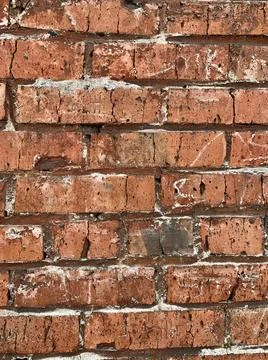 Old red brick wall. The bricks are laid in rows. Grunge stone texture. Stock Photos