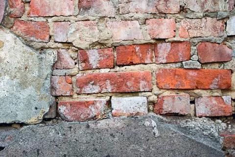 Old red brick wall with crumbling cement and damaged texture of aged masonry Stock Photos