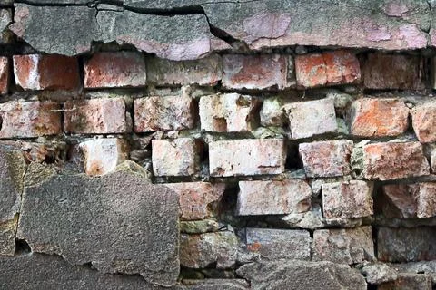 Old red brick wall with crumbling plaster and cracked surface texture Stock Photos