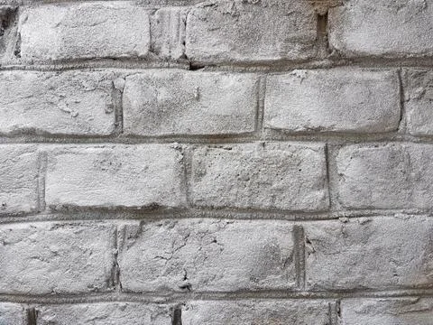 Old red brick wall with damaged white paint layer, closeup background photo t Stock Photos