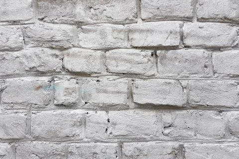Old red brick wall with damaged white paint layer, closeup background photo t Stock Photos