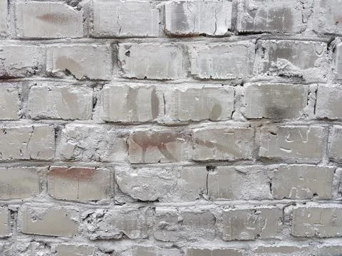 Old red brick wall with damaged white paint layer, closeup background photo t Foto stock