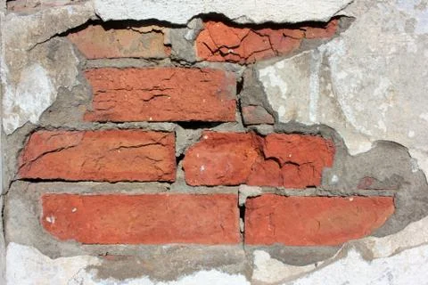 Old red brick wall with falling off cement textured background Stock Photos