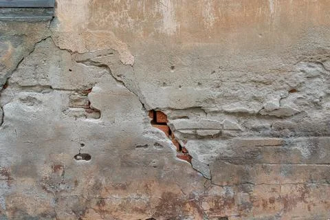 Old red brick wall with falling concrete plaster in yellow and brown color Stock Photos