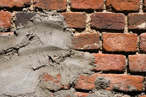 Old red brick wall with layer of plaster Stock Photos