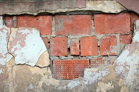 Old red brick wall with peeling plaster and cracked cement surface showing Stock Photos