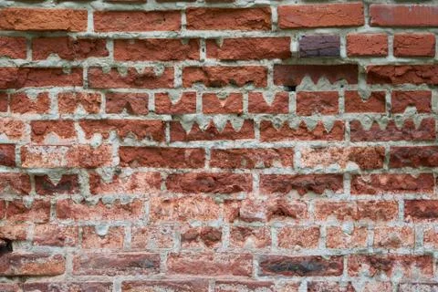 Old red brick wall of rectangular shape with triangular cutouts. Foto stock