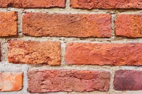 An old red brick wall with a rough cement seam Stock Photos