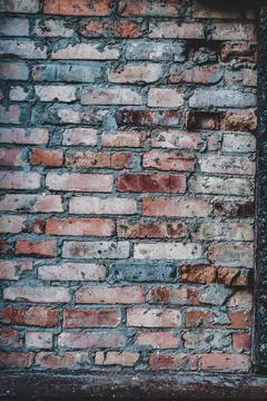 Old red brick wall, rough texture outdoors, weathered surface close-up, verti Stock Photos